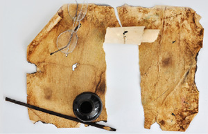 an old tattered piece of parchment paper with glasses and restoration tools resting nearby