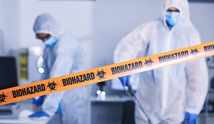 Professionals performing biohazard cleanup in a sealed area