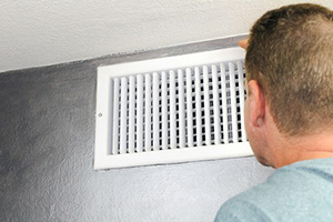 guy checking air duct for mold