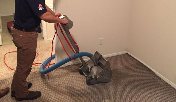 blue uniform man trying to water cleaing and restoration