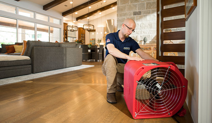 Technician setting up a fan to dry water damage