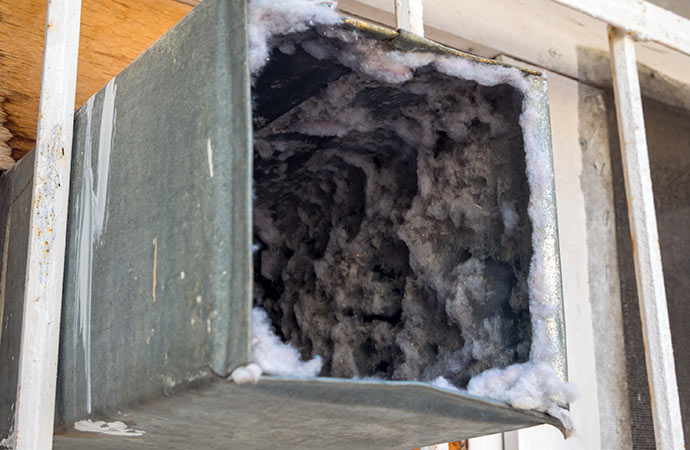 A dusty duct filled with dirt that needs cleaning.