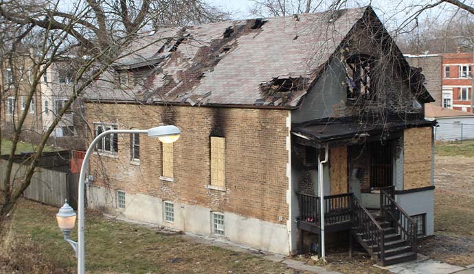 Fire damaged house with boarded up windows
