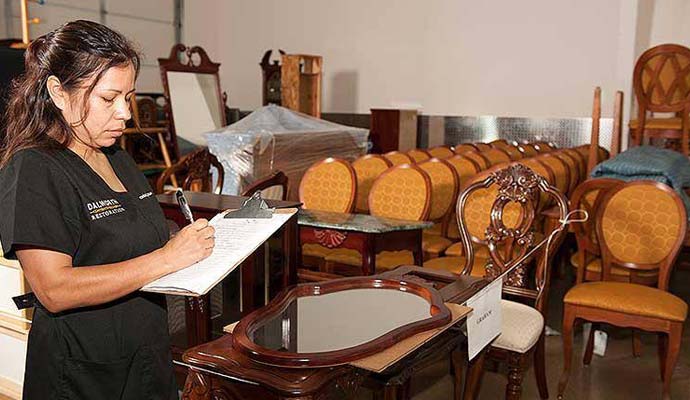 A technician taking inventory of furniture for restoration