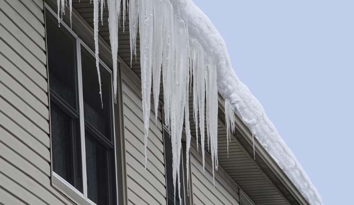 Heavy snow and large icicles hanging from roof