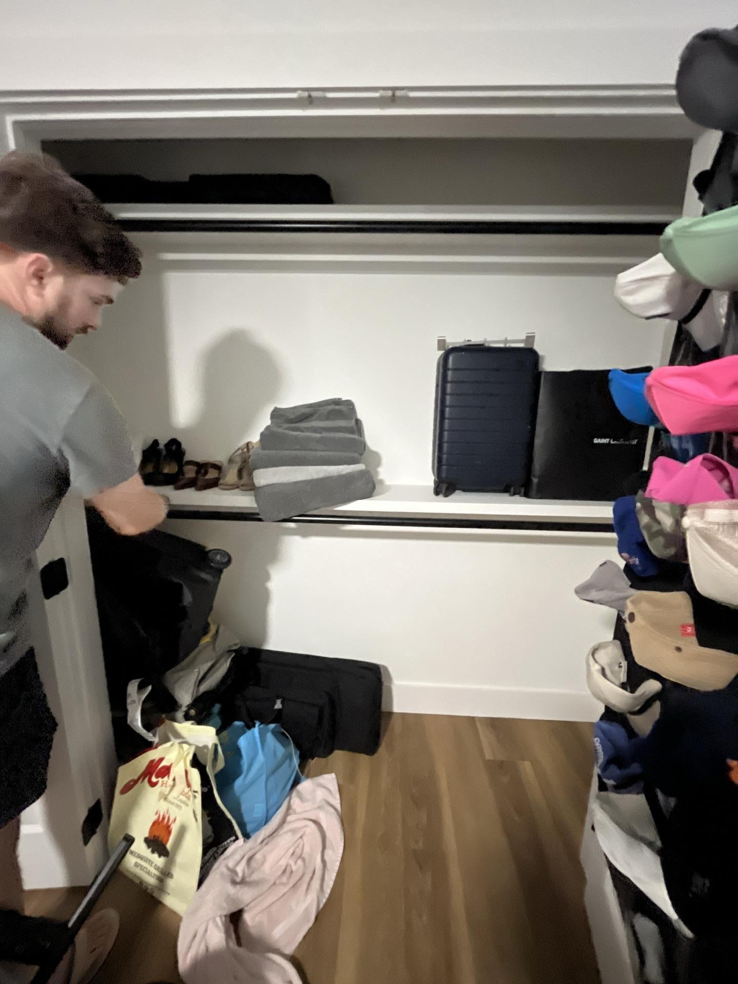Technician performing contents manipulation and moving items from a closet to prepare for water damage mitigation, ensuring effective structural drying and mold prevention.