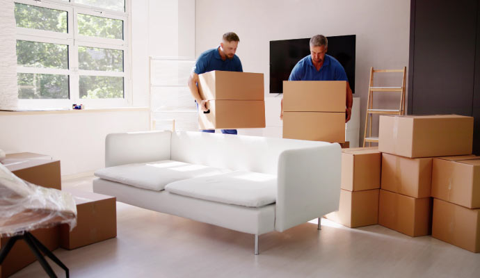 Professionals carrying packages in a living room during property restoration work