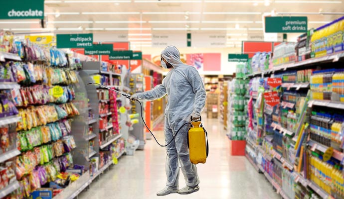 An expert in protective gear disinfecting a retail store