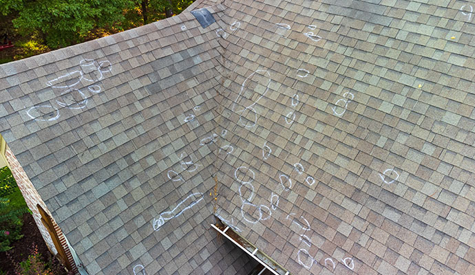 Roof inspection showing hail damage marked with white circles