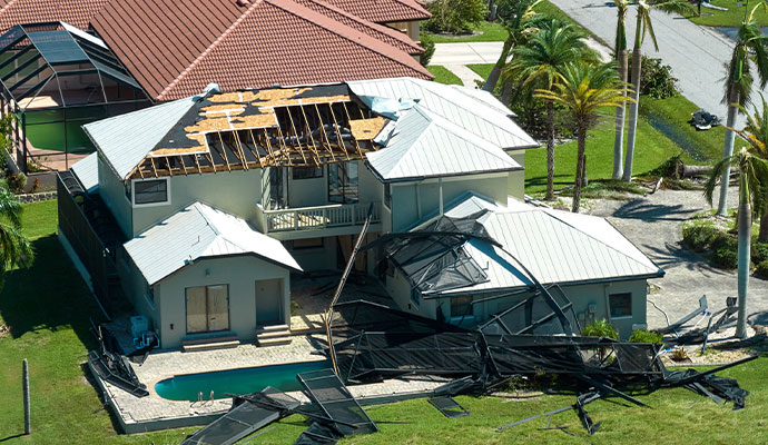 Severe structural roof damage and collapsed outdoor structures caused by a hurricane