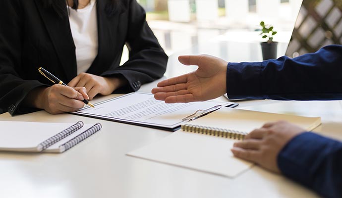 Professional assistant guiding client while signing important paperwork