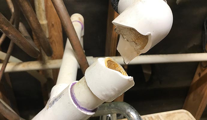 Broken PVC pipe with jagged edges after damage