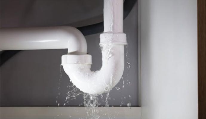 A plastic sink drain pipe leaking water