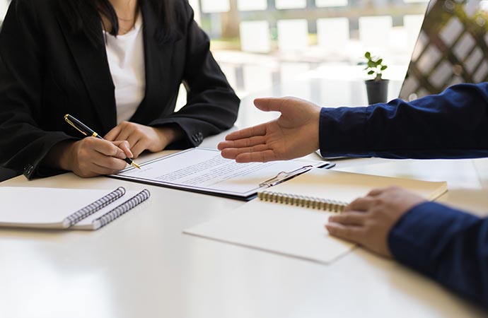 Professional assistant guiding client while signing important paperwork