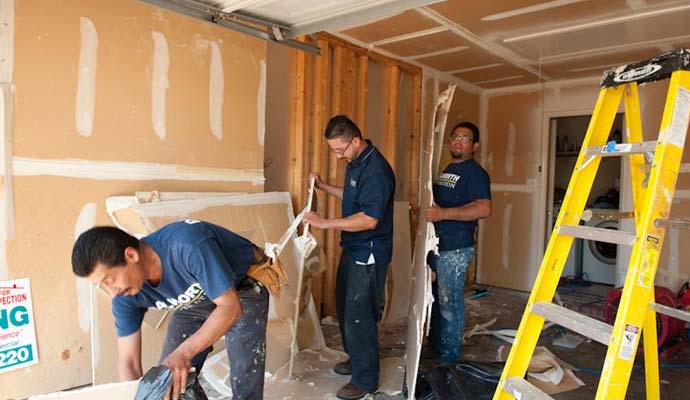 Restoration workers removing drywall demolition