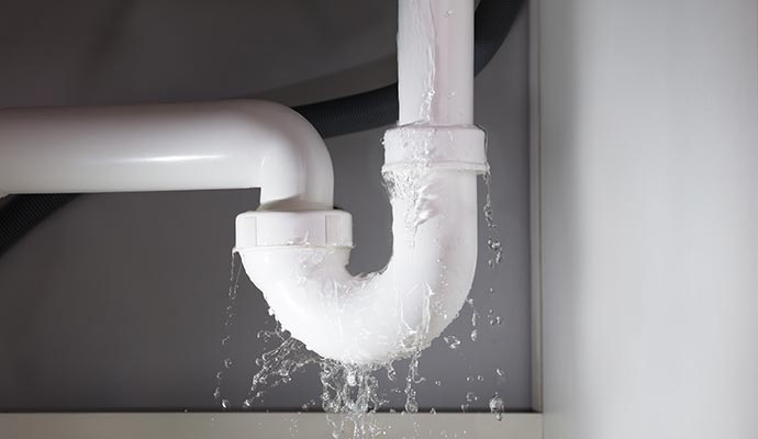 Water leaking from a white PVC pipe