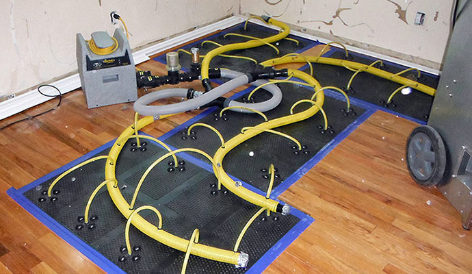 Floor water damage restoration in progress using professional equipment