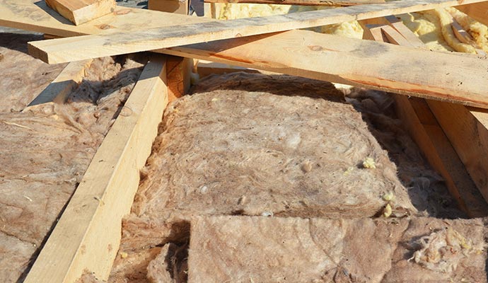 Roof insulation in progress with fibrous material and wooden framing
